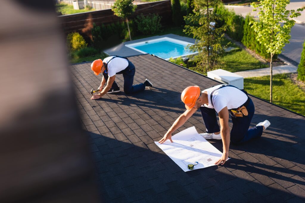 réparateurs-travaillant-sur-toit-plat-avec-plan-min